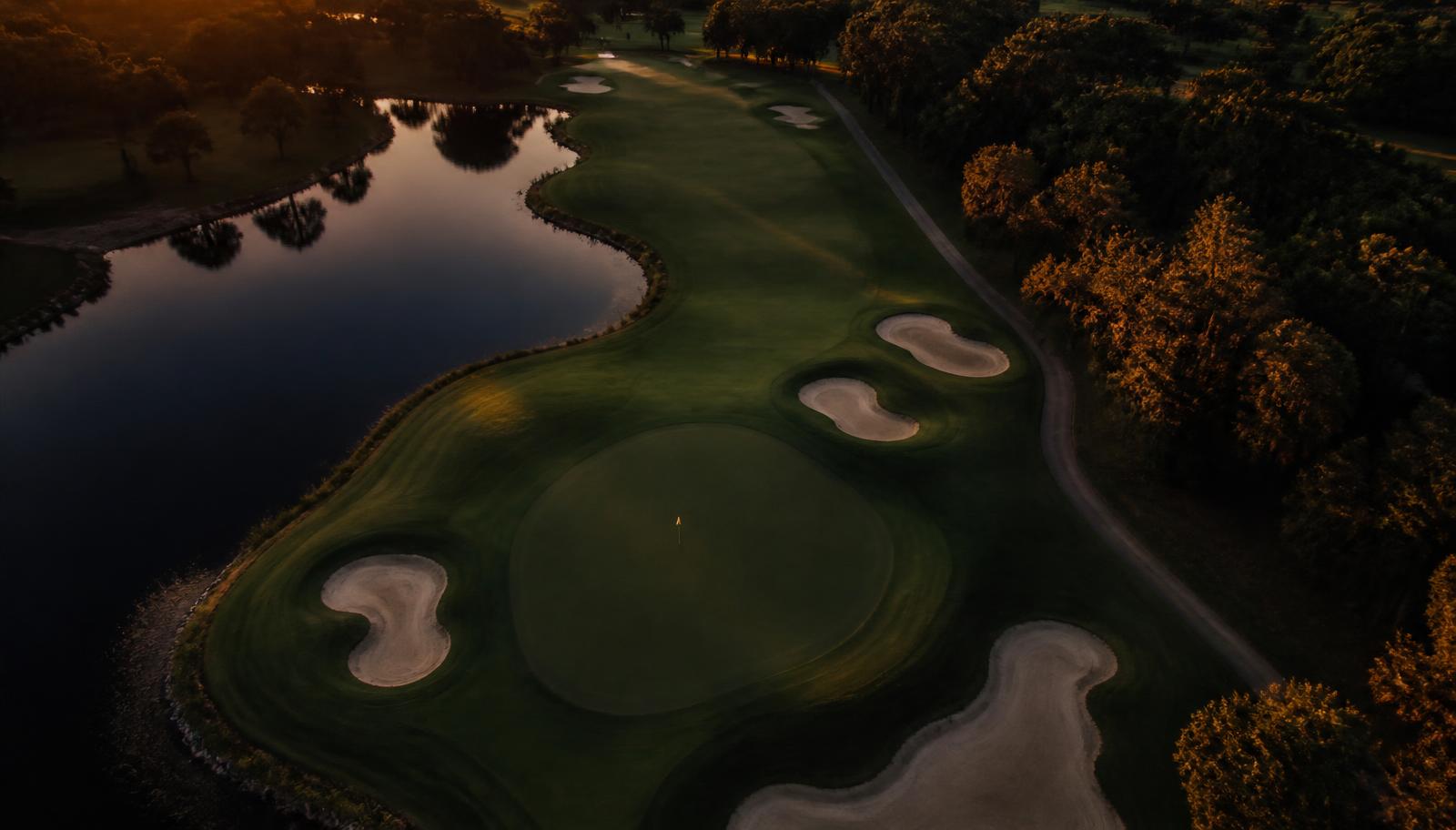 Aerial view of a golf hole with bunkers and water